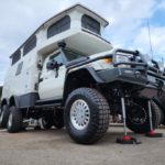 Redfoot Levelling - A white Expedition Off-Road Vehicle with a camper attached to it, suitable for expeditions.