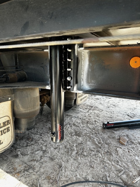 Hydraulic jack attached to rigid vehicle chassis