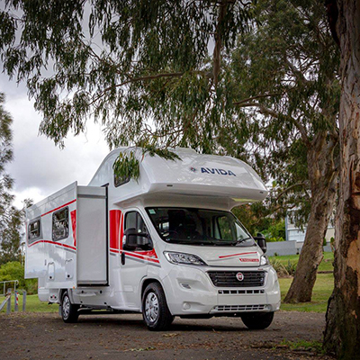 Redfoot Levelling - A red RV with the Redfoot Levelling Fiat 'AutoLift' System parked on a dirt road.